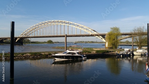 Boat near a bridge in a canal © Zhivko
