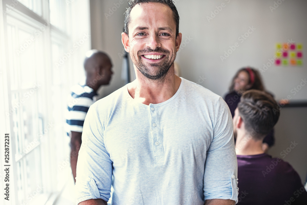 Fototapeta premium Designer smiling while standing in a bright office