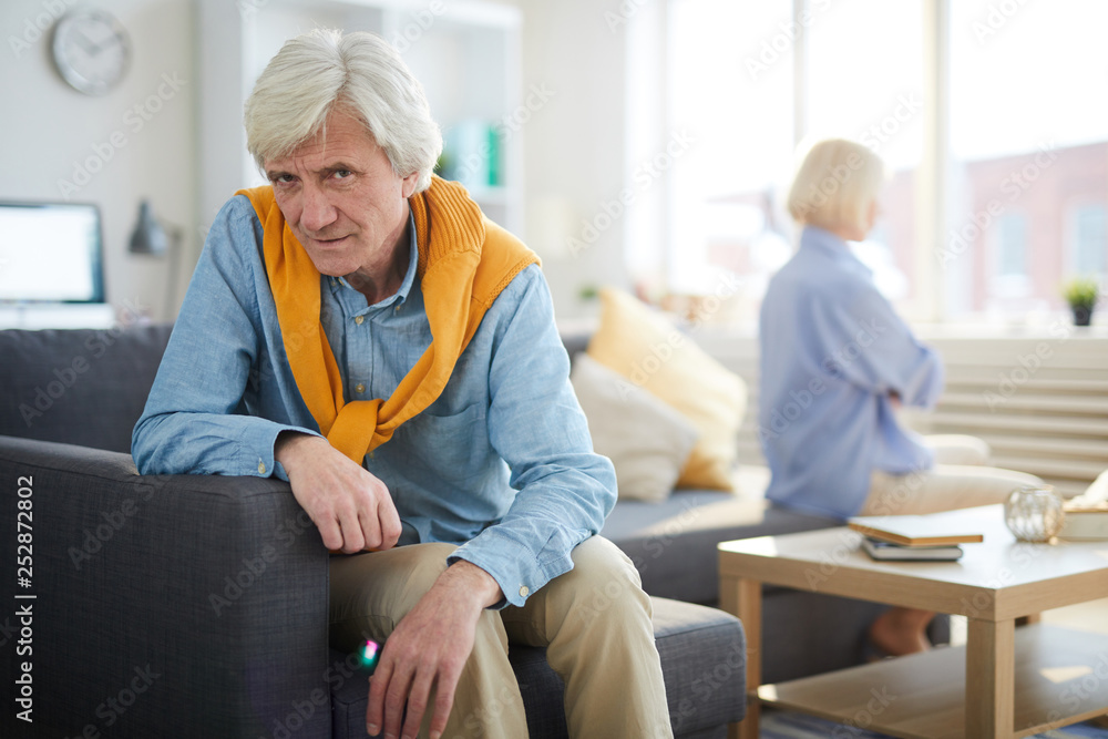 Fototapeta premium Portrait of modern senior couple fighting focus on sad man looking at camera, copy space