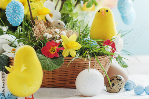 Easter composition with little chicks, spring flowers and colorful eggs.