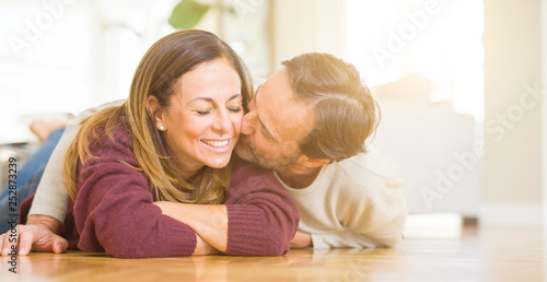 Beautiful romantic couple sitting together on the floor kissing in love at home