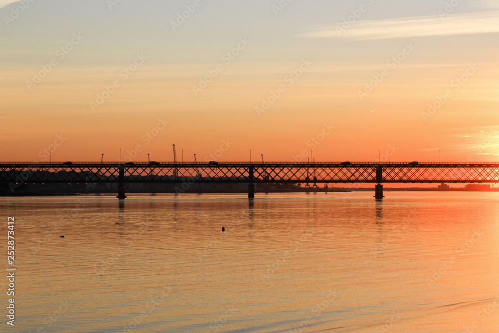 Bridge over the calm river with sunset colors. 