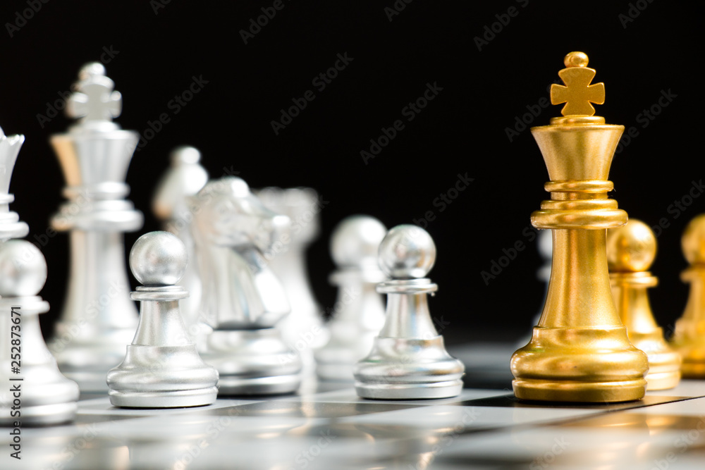 Gold king chess piece face with silver team on black background (Concept for company strategy, business decision and encounter the problem) Gold king chess piece face with silver team on black background (Concept for company strategy, business decision and encounter the problem)