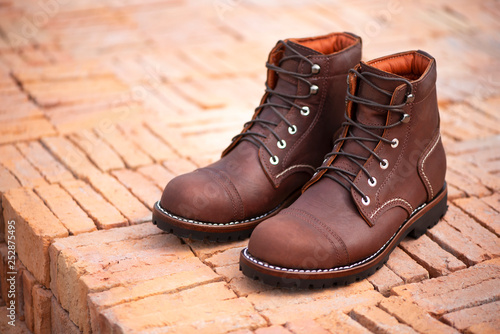 Men’s brown boots with genuin leathert. Fashion advertising boots photo on brick background. photo
