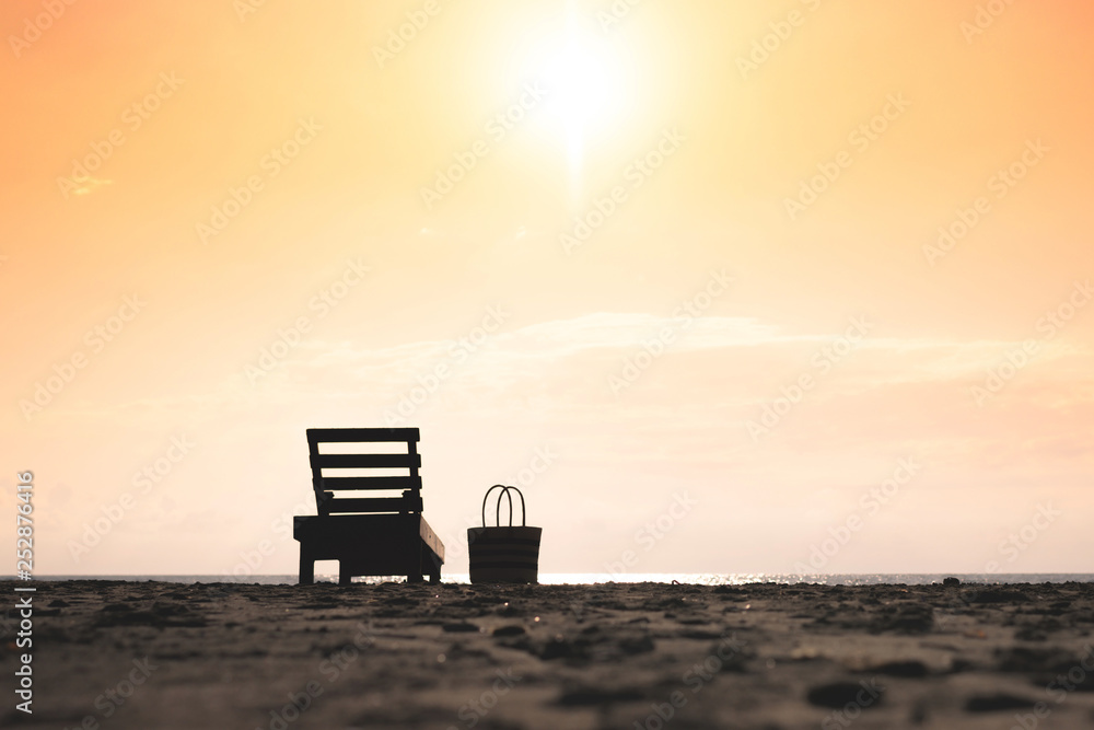 Wooden lounger on the beach on sunset sky background