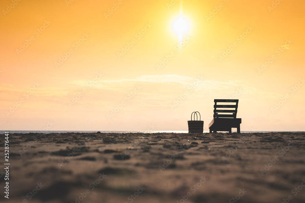 Wooden lounger on the beach on sunset sky background