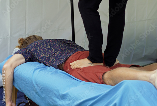 Masseuse walking on client's back 