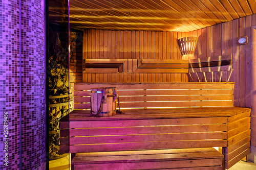 Interior of wooden finnish sauna with birch broom, bucket and stove. The Finnish sauna is a substantial part of their culture © dimaris