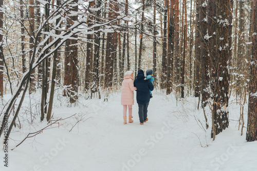 Walking family with a child. Family walks in nature in winter. Winter family walk in nature. A lot of snow.