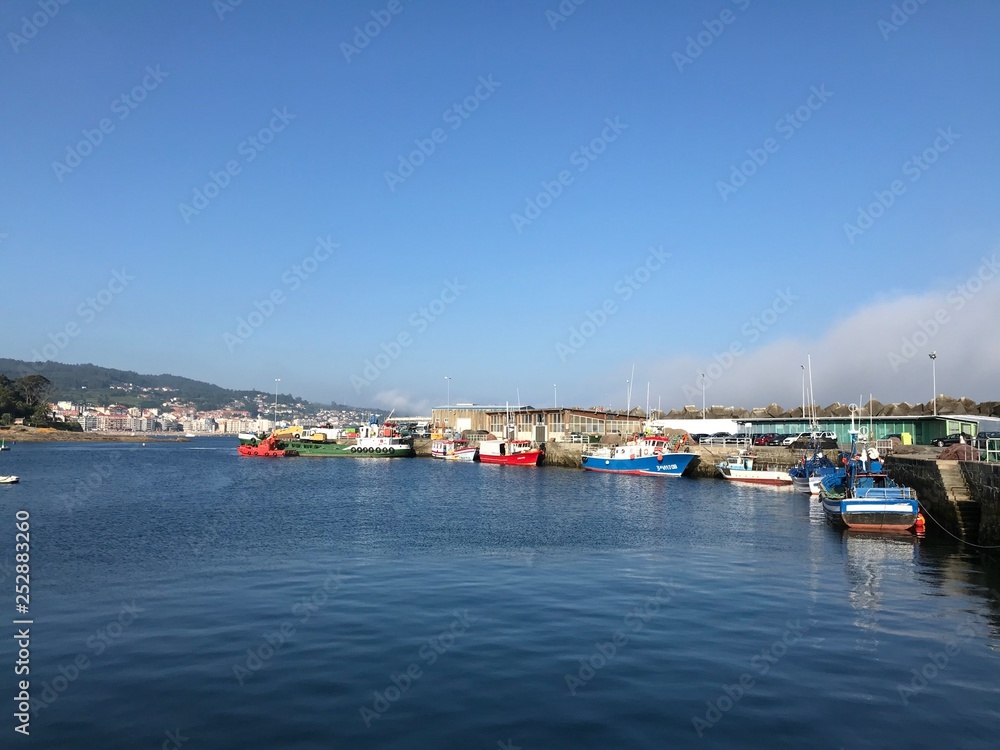 Some fishing boats docked at port during summer in Portonovo Spain