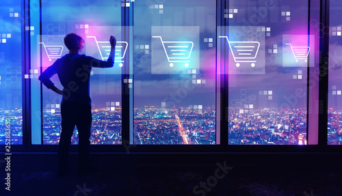 Foto Online shopping theme with man writing on large windows high above a sprawling c