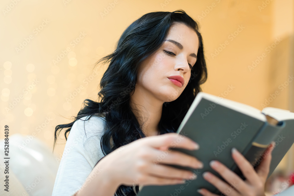 Young woman with a book in her home