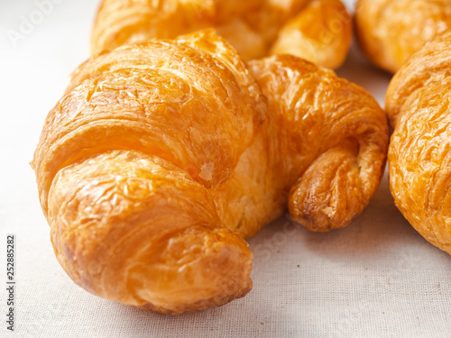 Close up of fresh croissants on white towel.