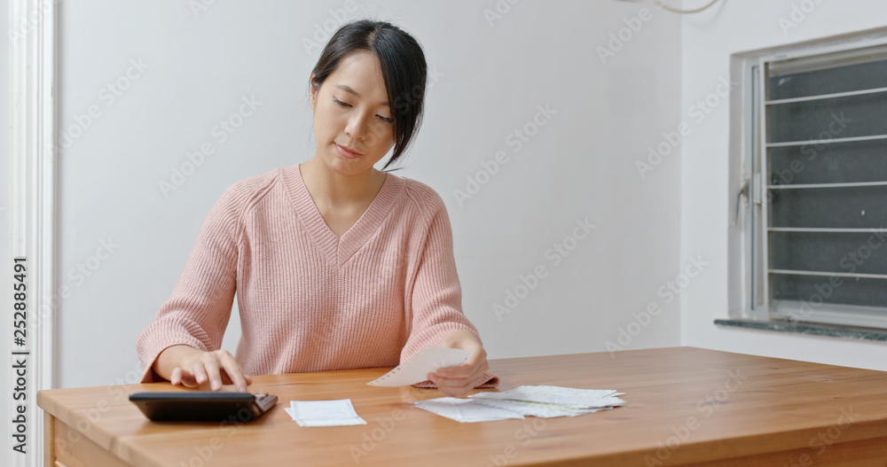Woman calculate the expenditure for daily use Woman calculate the expenditure for daily use