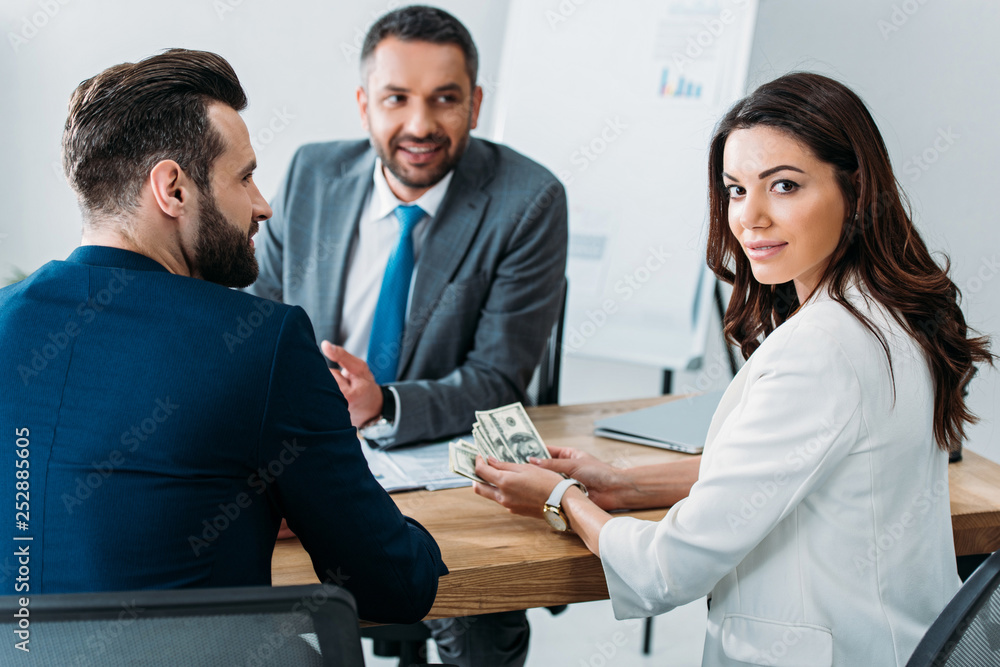 selective focus of investor in suit holding money at office