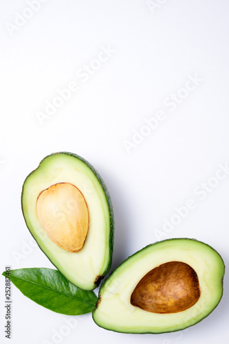 Avocado on white background. Tropical background with avocado and leaf. Flat lay. Top view, copy space