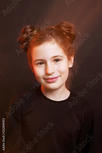 Cute little girl. Mixed light, black background, black dress.