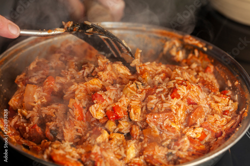 Chicken and Chorizo Jambalaya being stirred in a pan