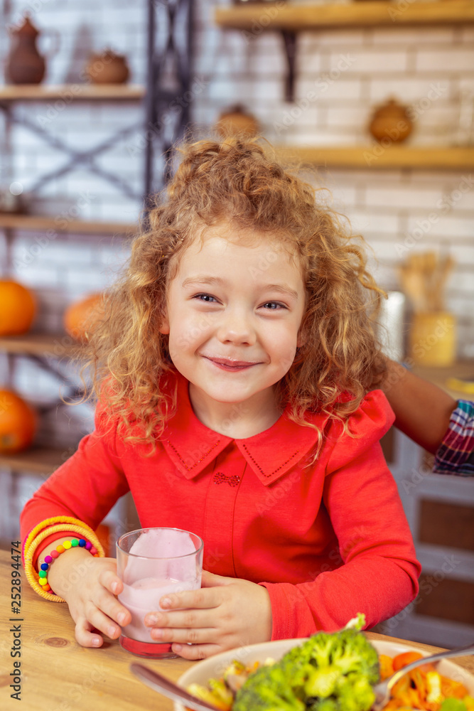 Positive delighted little female posing on camera Positive delighted little female posing on camera