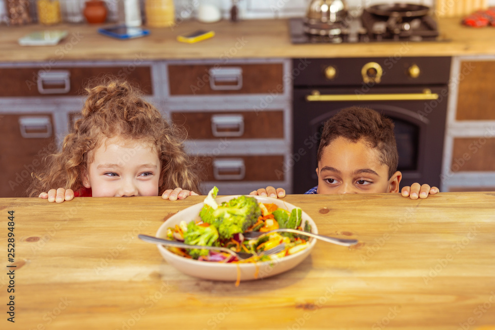 Close up of cheerful kids that looking at plate Close up of cheerful kids that looking at plate