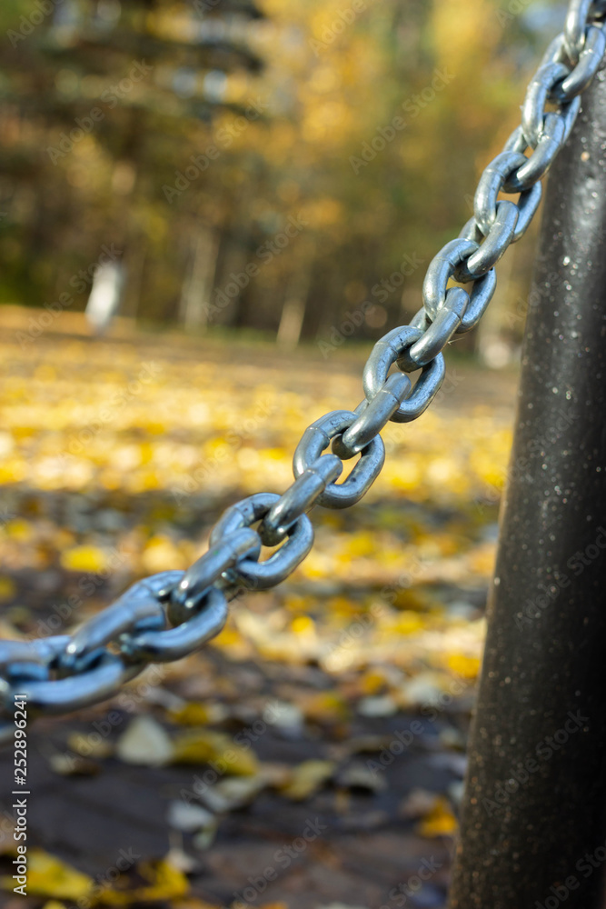 iron chain fence in autumn park iron chain fence in autumn park