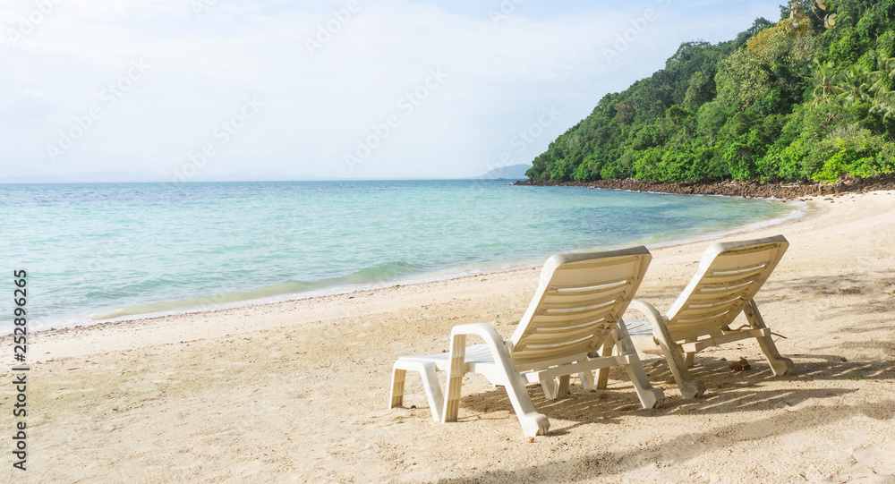Two empty chair on beach with forest mountain
