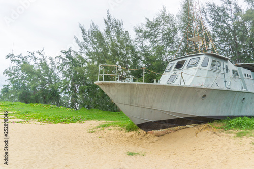 Battle metal ship on sand beach