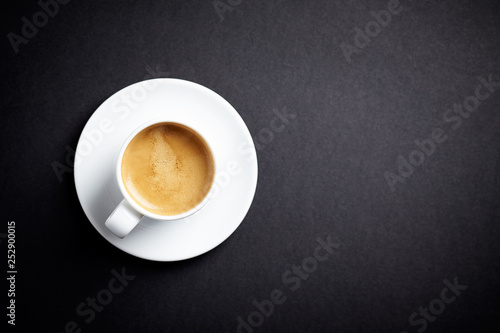 Cup of coffee on black background. Top view. Copy space.