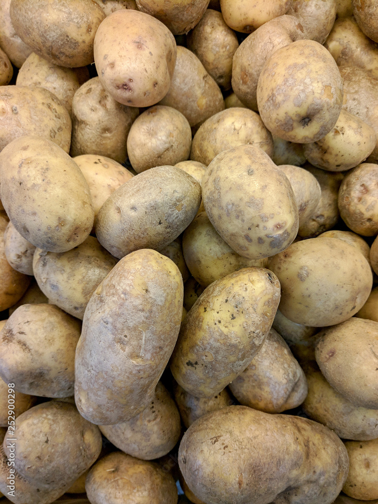 Potatoes at market stall as background, vertical view Potatoes at market stall as background, vertical view