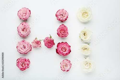 Inscription Hi by rose flowers on white background