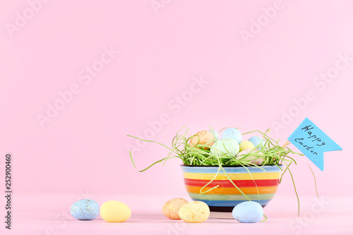 Colorful eggs with text Happy Easter on pink background