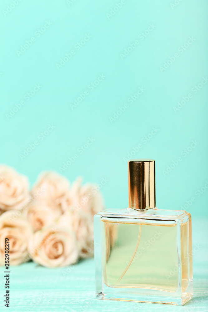 Perfume bottle with roses on mint background Perfume bottle with roses on mint background