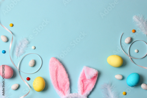  Easter composition of painted eggs and feathers on a colored background. Easter background