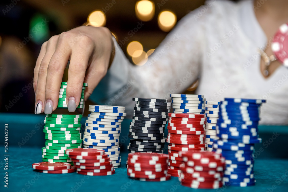 Female hands with piles of poker chips closeup