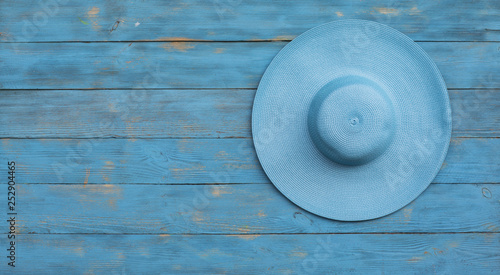 blue wide-brimmed hat on blue wooden background