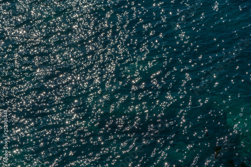 Sun glare on dark water. Surface of sea in Sunny weather, top view.
