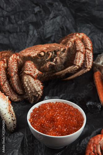Closeup of of hairy crab with plate of red caviar