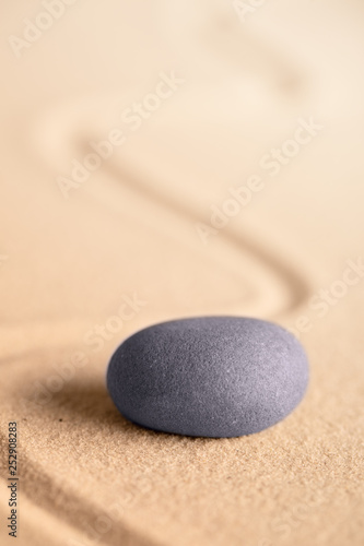 zen meditation stone in a Japanese garden with raked sand. Rock for focus and concentration for balance and spirituality.