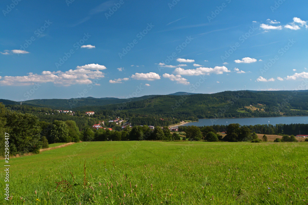 Panorama view of Lipno Lake with blue sky and green meadow, Czech Repubilc