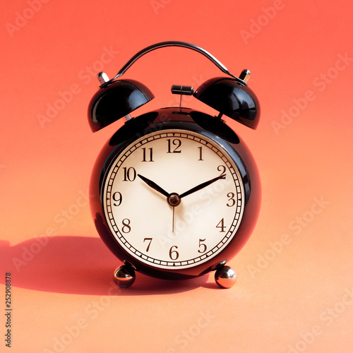 Close up rblack alarm clock on pastel background photo