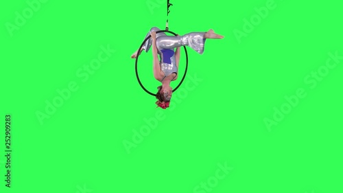 Professional Aerial Hoop Artist spins and performs wearing a circus suit over a green screen.