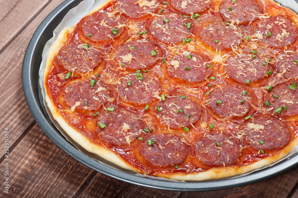 Pizza with salami and cheese on the old wooden background. Pizza with salami and cheese on the old wooden background.