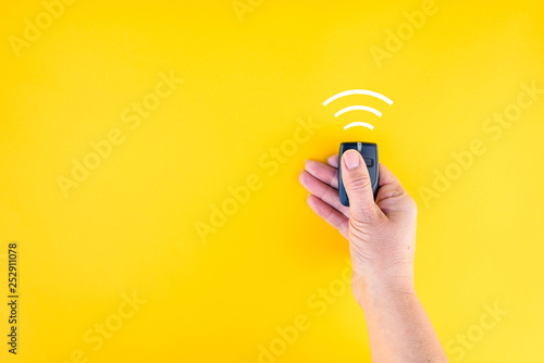 woman hand holds remote controller on isolated background photo