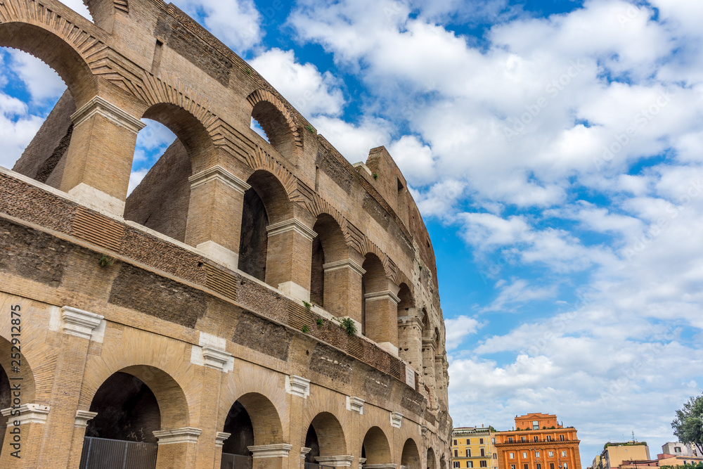 Facade of the Great Roman Colosseum (Coliseum, Colosseo), also known as the Flavian Amphitheatre. Famous world landmark. Scenic urban landscape.