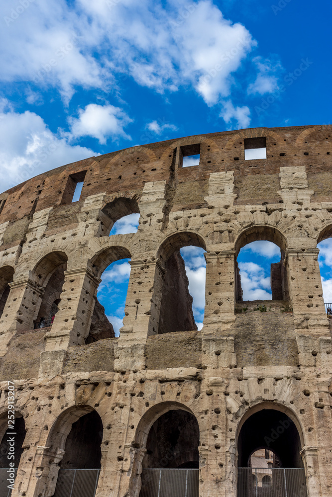 Facade of the Great Roman Colosseum (Coliseum, Colosseo), also known as the Flavian Amphitheatre. Famous world landmark. Scenic urban landscape.