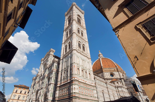 White stone tower of 14th century Cattedrale di Santa Maria del Fiore, Florence. Reliefs on historical walls of italian cathedral, UNESCO World Heritage Site