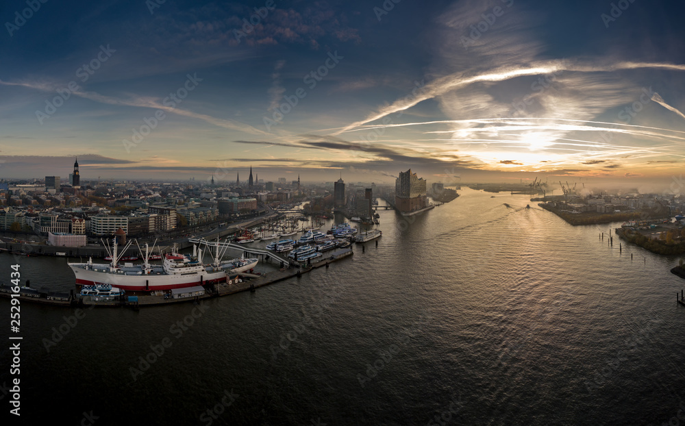 Luftaufnahme von Hamburg mit Elbphilharmonie, Landunsgbrücken, Speicherstadt und Hafencity bei Sonnenaufgang