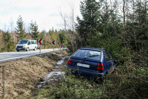 A car destroyed during the traffic accident. The car is abandoned and stands by the road in the trees. 