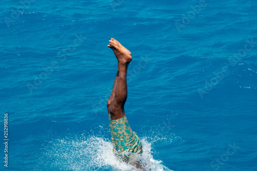 maldivian man diving from boat photo