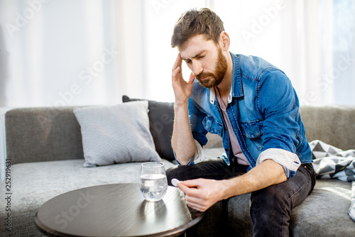 Photography Man drinking some medicines feeling bad or having hangover after the alcohol par